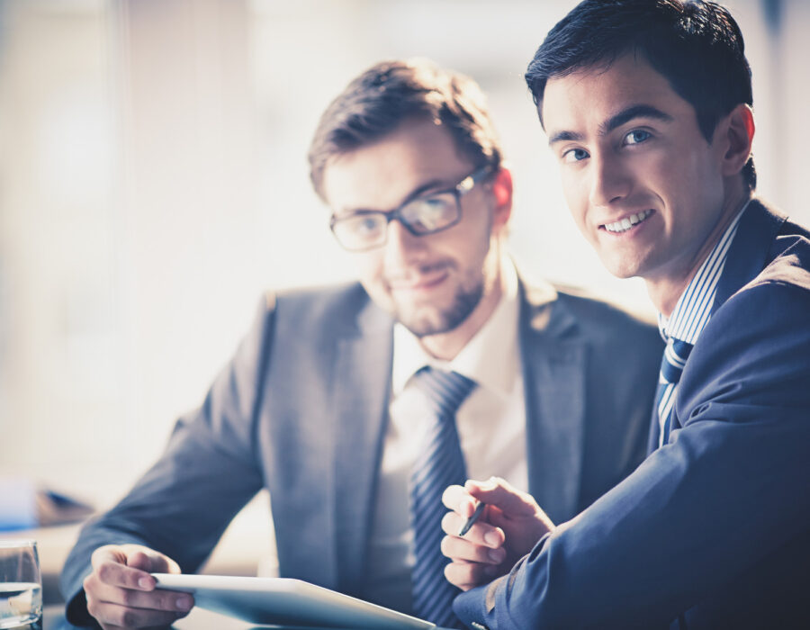 Image of smart young businessmen looking at camera at meeting